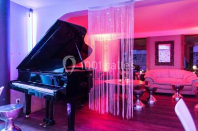 Comptoir en verre avec base en bois sculpté, entouré de portants métalliques avec des cintres noirs dans un espace moderne.