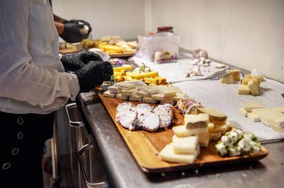 Plateau de petites assiettes garnies, posé sur une table en bois devant des vignes en arrière-plan.