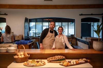 Plateau de petites assiettes garnies, posé sur une table en bois devant des vignes en arrière-plan.