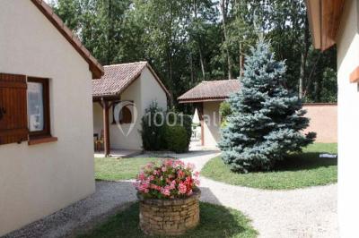 Cuisine rustique avec un bar en bois, éclairage chaleureux, cafetière et ustensiles suspendus au mur.