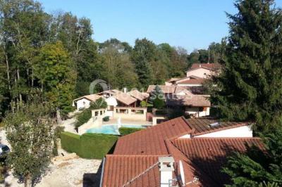 Cuisine rustique avec un bar en bois, éclairage chaleureux, cafetière et ustensiles suspendus au mur.