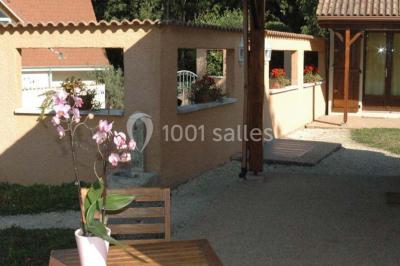 Cuisine rustique avec un bar en bois, éclairage chaleureux, cafetière et ustensiles suspendus au mur.