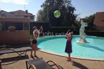 Cuisine rustique avec un bar en bois, éclairage chaleureux, cafetière et ustensiles suspendus au mur.