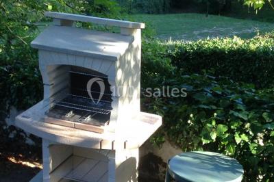 Cuisine rustique avec un bar en bois, éclairage chaleureux, cafetière et ustensiles suspendus au mur.
