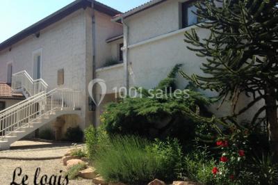 Cuisine rustique avec un bar en bois, éclairage chaleureux, cafetière et ustensiles suspendus au mur.