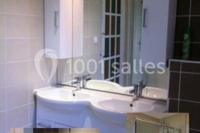 Cuisine rustique avec un bar en bois, éclairage chaleureux, cafetière et ustensiles suspendus au mur.