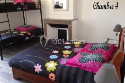 Cuisine rustique avec un bar en bois, éclairage chaleureux, cafetière et ustensiles suspendus au mur.