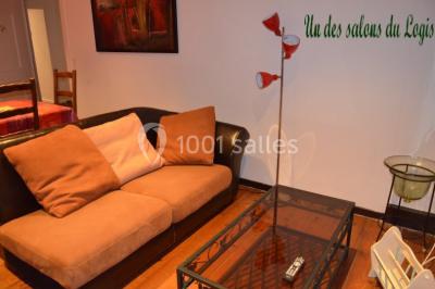 Cuisine rustique avec un bar en bois, éclairage chaleureux, cafetière et ustensiles suspendus au mur.