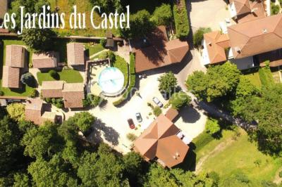 Cuisine rustique avec un bar en bois, éclairage chaleureux, cafetière et ustensiles suspendus au mur.