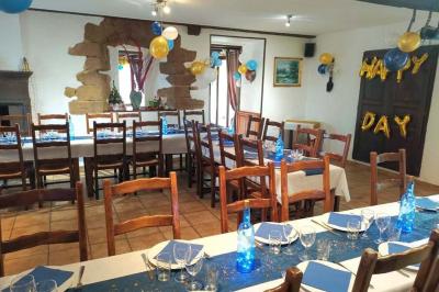 Cuisine rustique avec un bar en bois, éclairage chaleureux, cafetière et ustensiles suspendus au mur.