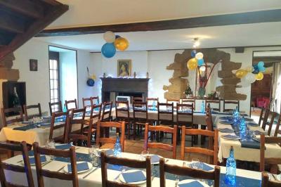 Cuisine rustique avec un bar en bois, éclairage chaleureux, cafetière et ustensiles suspendus au mur.