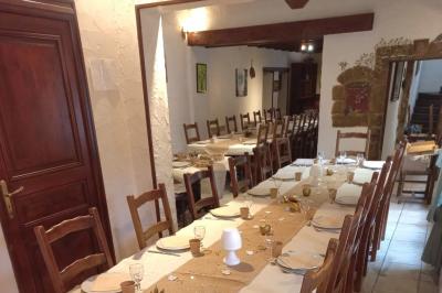 Cuisine rustique avec un bar en bois, éclairage chaleureux, cafetière et ustensiles suspendus au mur.