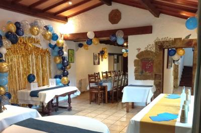 Cuisine rustique avec un bar en bois, éclairage chaleureux, cafetière et ustensiles suspendus au mur.