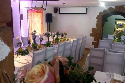 Cuisine rustique avec un bar en bois, éclairage chaleureux, cafetière et ustensiles suspendus au mur.