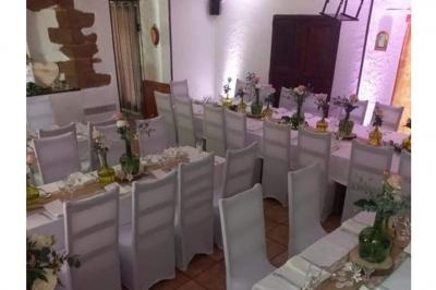 Cuisine rustique avec un bar en bois, éclairage chaleureux, cafetière et ustensiles suspendus au mur.