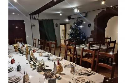 Cuisine rustique avec un bar en bois, éclairage chaleureux, cafetière et ustensiles suspendus au mur.