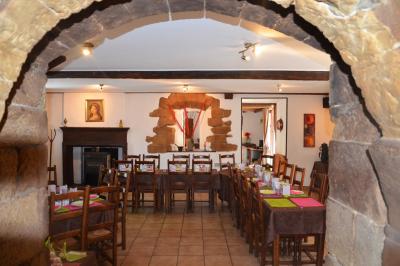 Cuisine rustique avec un bar en bois, éclairage chaleureux, cafetière et ustensiles suspendus au mur.