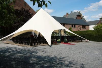 Structure gonflable noire avec cibles circulaires rouges et blanches, installée sur une pelouse en plein air.