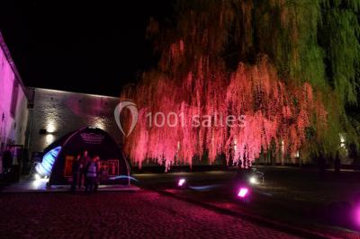 Structure gonflable noire avec cibles circulaires rouges et blanches, installée sur une pelouse en plein air.