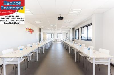 Bâtiment moderne à trois étages avec enseignes ’Espace Entreprise’ et ’Restaurant’, situé sur un parking dégagé.