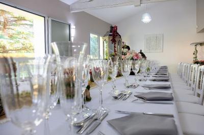 Buffet avec boissons, viennoiseries, fruits et condiments disposés sur deux tables dans une salle lumineuse.