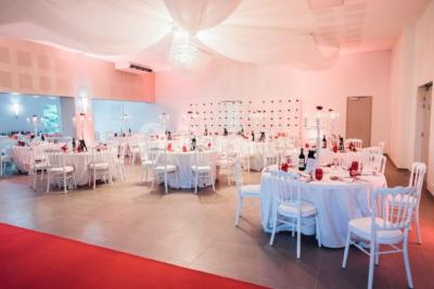 Buffet avec boissons, viennoiseries, fruits et condiments disposés sur deux tables dans une salle lumineuse.