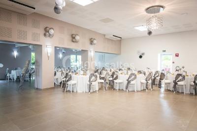 Buffet avec boissons, viennoiseries, fruits et condiments disposés sur deux tables dans une salle lumineuse.