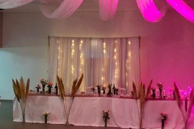 Buffet avec boissons, viennoiseries, fruits et condiments disposés sur deux tables dans une salle lumineuse.