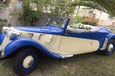 Buffet avec boissons, viennoiseries, fruits et condiments disposés sur deux tables dans une salle lumineuse.