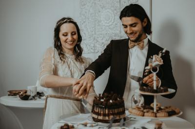 Buffet avec boissons, viennoiseries, fruits et condiments disposés sur deux tables dans une salle lumineuse.