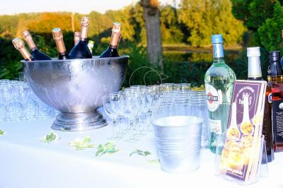 Buffet avec boissons, viennoiseries, fruits et condiments disposés sur deux tables dans une salle lumineuse.