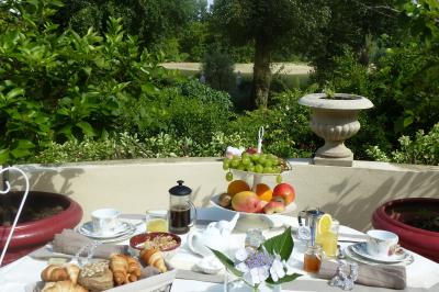 Buffet avec boissons, viennoiseries, fruits et condiments disposés sur deux tables dans une salle lumineuse.