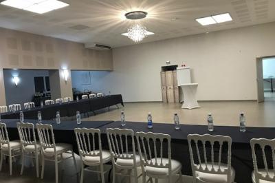 Buffet avec boissons, viennoiseries, fruits et condiments disposés sur deux tables dans une salle lumineuse.