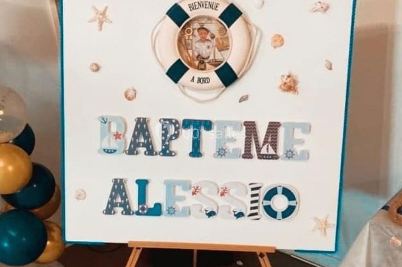 Panneau décoratif pour un baptême avec le prénom ’Alessio’, des motifs marins et une photo encadrée.