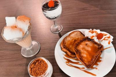 Miniature Location salle La Penne-sur-Huveaune (Bouches-du-Rhône) - Le Pajuto #18 Deux tranches de pain perdu avec glace vanille, chantilly, caramel et une framboise, servies sur une assiette blanche.