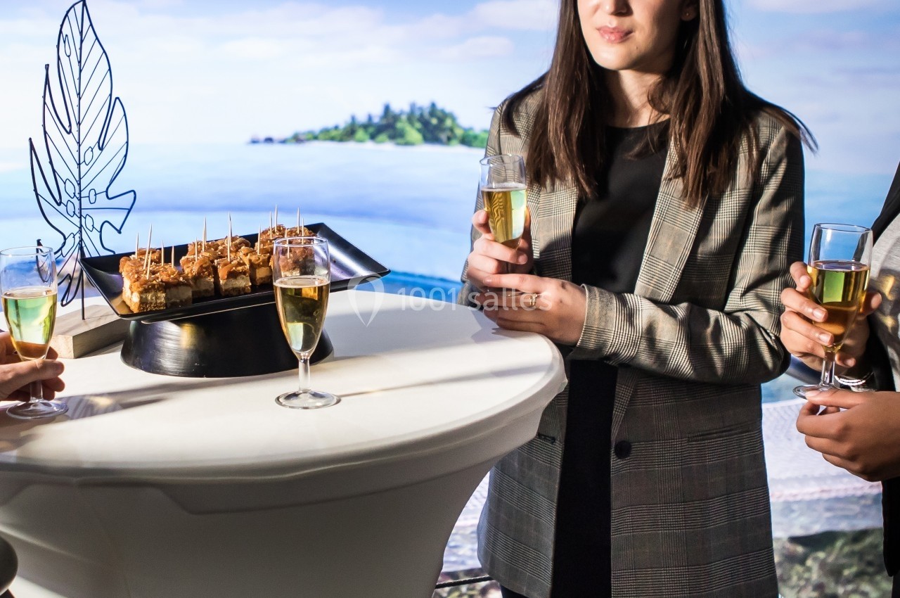Location salle Montpellier (Hérault) - Planet Ocean Montpellier #4 Trois personnes debout autour d'une table haute avec des amuse-bouches et des verres de champagne, en arrière-plan un…