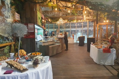 Un mannequin en combinaison d'astronaute près d'un buffet éclairé dans une salle à thème spatial.