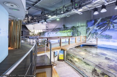 Un mannequin en combinaison d'astronaute près d'un buffet éclairé dans une salle à thème spatial.