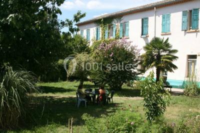 Des personnes en tenue de karaté pratiquent des exercices collectifs dans une salle aux murs en pierre et parquet en bois.