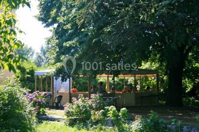 Des personnes en tenue de karaté pratiquent des exercices collectifs dans une salle aux murs en pierre et parquet en bois.