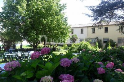 Des personnes en tenue de karaté pratiquent des exercices collectifs dans une salle aux murs en pierre et parquet en bois.