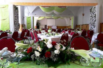 Des personnes en tenue de karaté pratiquent des exercices collectifs dans une salle aux murs en pierre et parquet en bois.