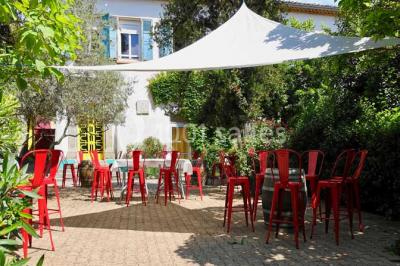 Des personnes en tenue de karaté pratiquent des exercices collectifs dans une salle aux murs en pierre et parquet en bois.