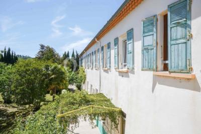 Des personnes en tenue de karaté pratiquent des exercices collectifs dans une salle aux murs en pierre et parquet en bois.