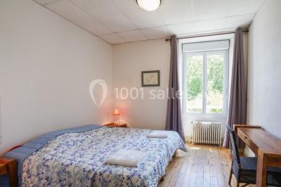 Des personnes en tenue de karaté pratiquent des exercices collectifs dans une salle aux murs en pierre et parquet en bois.