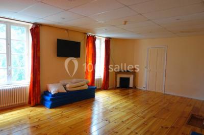 Des personnes en tenue de karaté pratiquent des exercices collectifs dans une salle aux murs en pierre et parquet en bois.