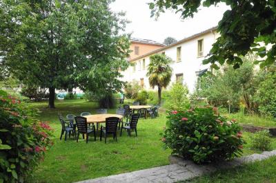 Des personnes en tenue de karaté pratiquent des exercices collectifs dans une salle aux murs en pierre et parquet en bois.
