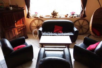 Chambre lumineuse avec murs jaunes, deux lits simples, décorations florales et une peluche sur un lit.