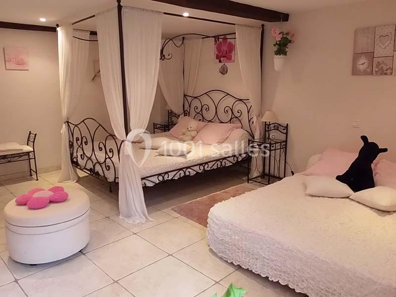 Chambre lumineuse avec deux lits à baldaquin, décorée de tons clairs et d'éléments romantiques.