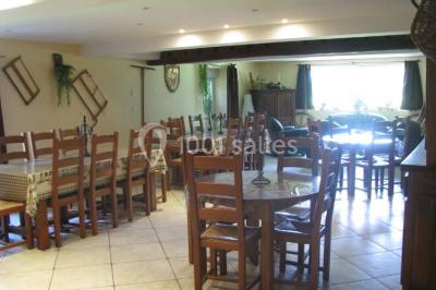 Chambre lumineuse avec murs jaunes, deux lits simples, décorations florales et une peluche sur un lit.